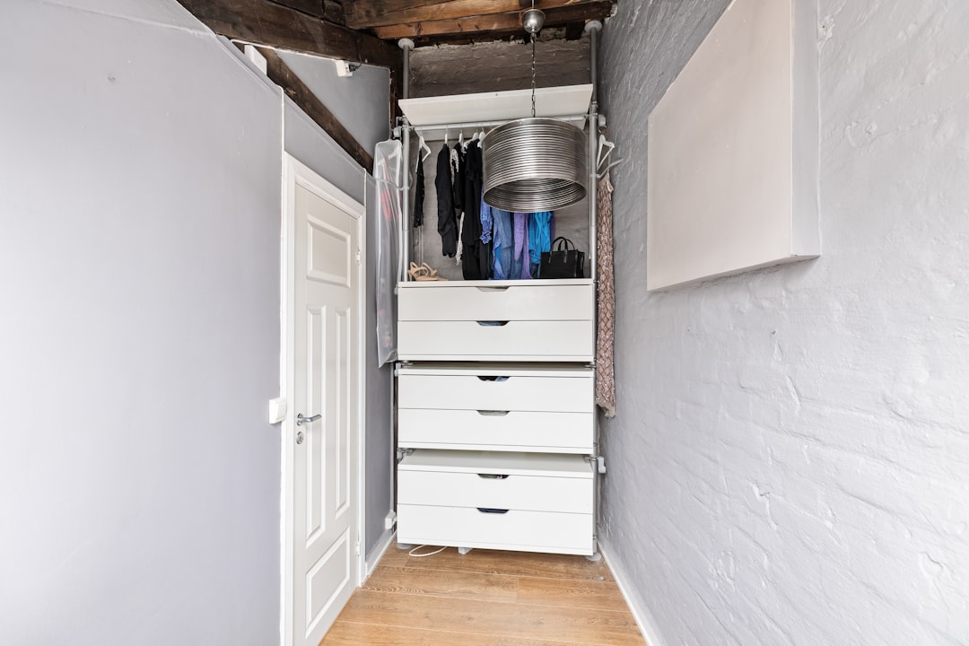 a-narrow-hallway-with-a-white-cabinet-and-drawers-r4pegmndsn4